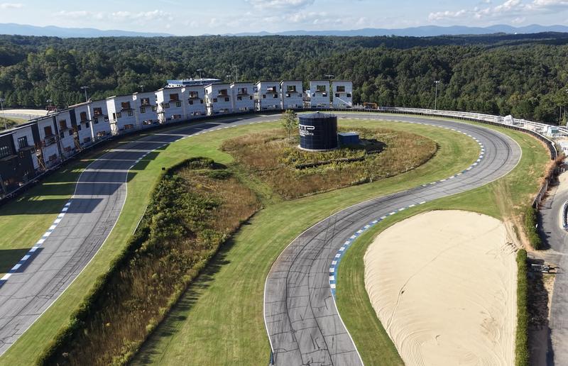 The Carousel at Atlanta Motorsports Park from above, the water tower in its center and the Circuit Villas wrapping the outside of the corner, with the Blue Ridge on the horizon